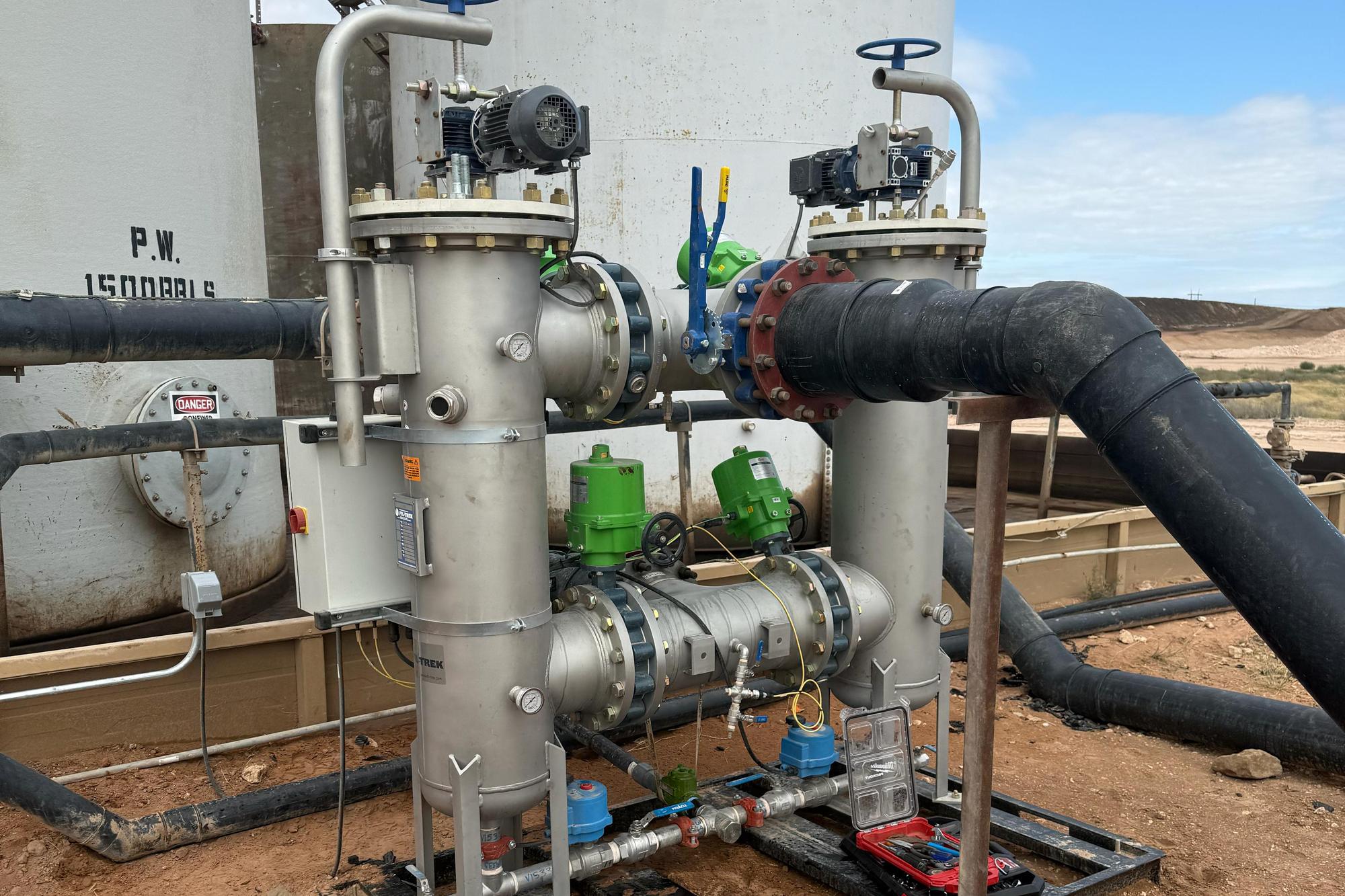 An IP Filtration automated self-cleaning duplex strainer skid piped into a 1,500-barrel produced water tank at a salt water disposal site in the Permian Basin
